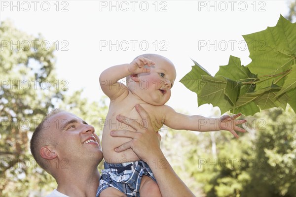 Father holding baby outdoors