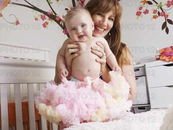 Mother holding baby girl in tutu
