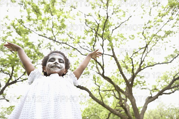 Black girl wearing face paint outdoors