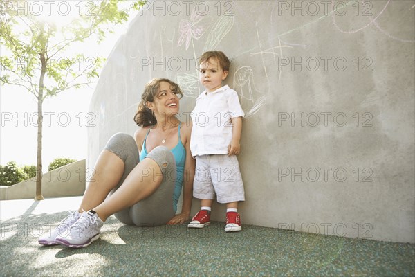 Mixed race mother sitting with son outdoors