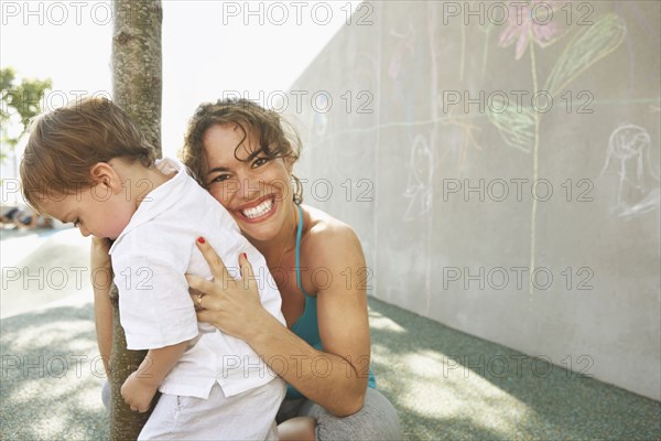 Mixed race mother hugging son outdoors