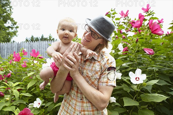 Father carrying baby daughter in park