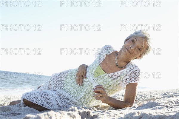 Senior woman laying on tropical beach
