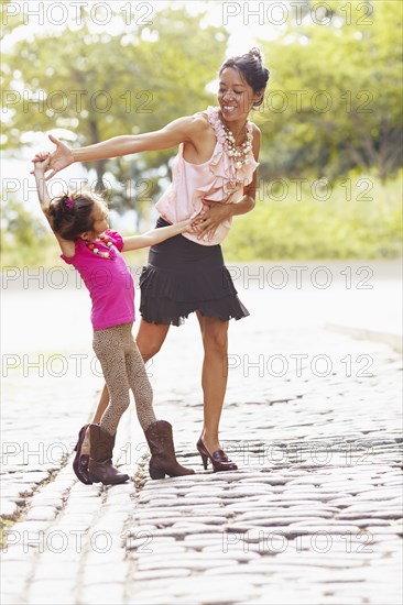 Mother and daughter posing on city street