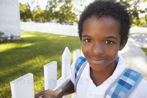 Mixed race boy smiling on suburban street