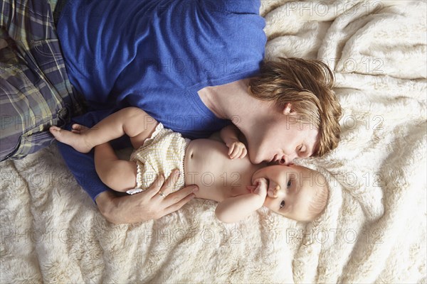 Father and baby laying on blanket