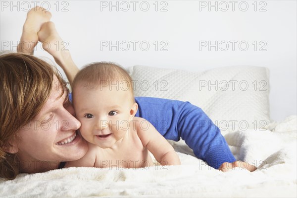 Father and baby laying on blanket