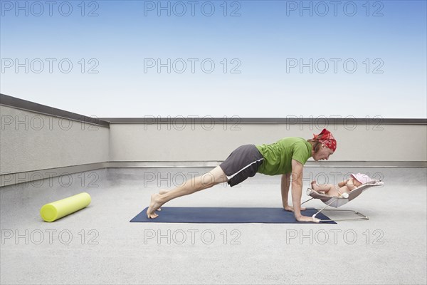 Father practicing yoga and talking to baby
