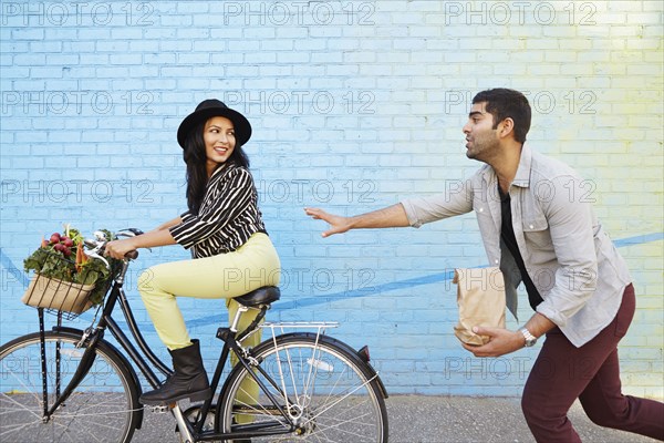 Indian man chasing girlfriend on bicycle