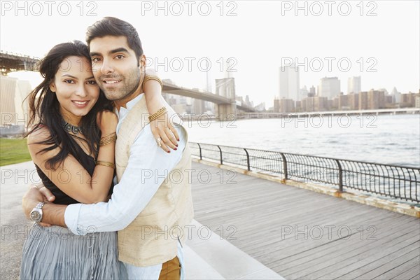 Indian couple hugging by New York city skyline