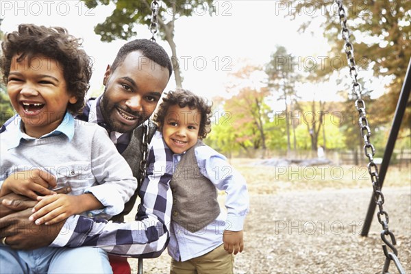 Father and sons playing together in park