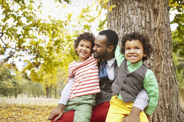 Father and sons smiling in park