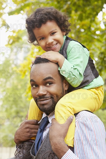 Father carrying son in park