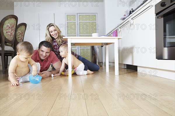 Caucasian family playing on kitchen floor