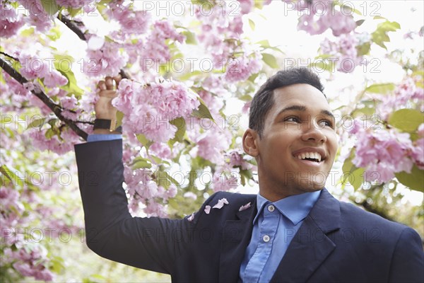 Man in suit walking under flowering tree