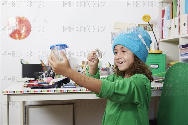 Mixed race girl doing science experiments at desk