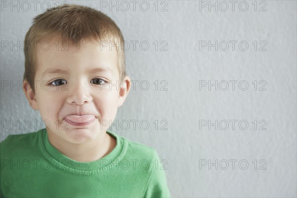 Close up of mixed race boy sticking out tongue