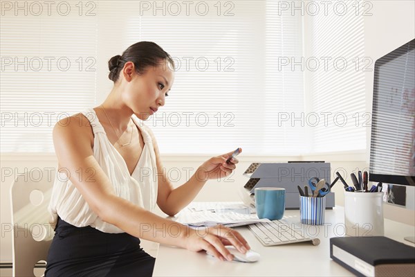 Chinese businesswoman shopping online with credit card