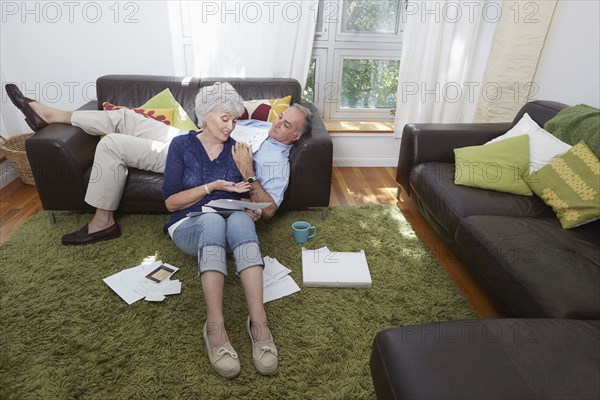 Older couple looking at photographs in living room