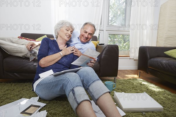 Older couple looking at photographs in living room