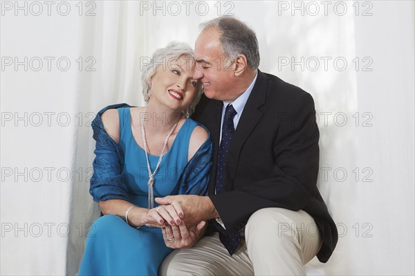 Smiling older couple in formal wear hugging