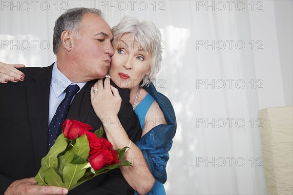 Older couple in formal wear kissing