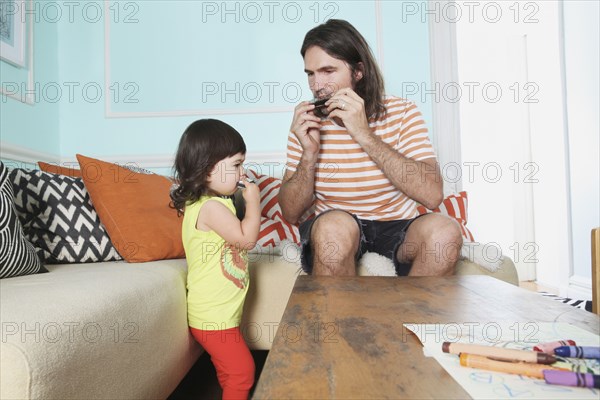 Father and daughter playing in living room