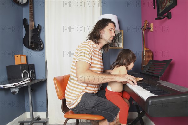 Father and daughter playing piano