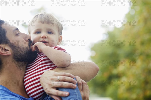Caucasian father kissing baby son