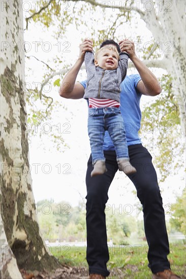 Caucasian father playing with baby son outdoors