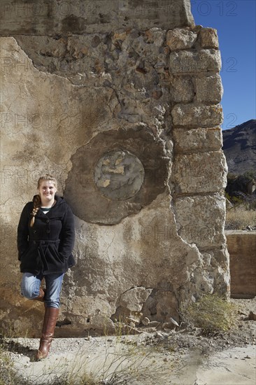 Tourist smiling near relief sculpture on wall of ruins