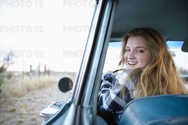 Smiling woman driving vintage car