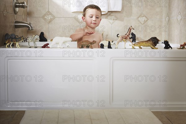 Caucasian boy playing in bathtub
