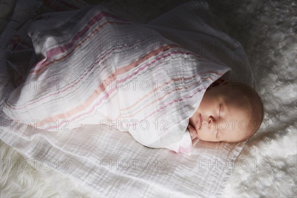 Newborn baby swaddled in blanket