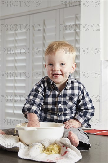 Caucasian boy playing with food in kitchen