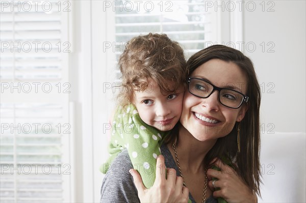 Caucasian mother carrying daughter piggyback