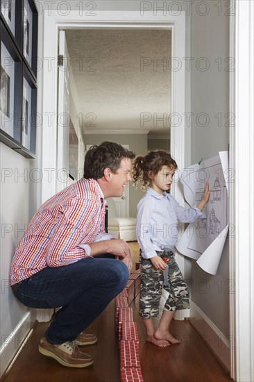 Caucasian father and daughter talking in hallway