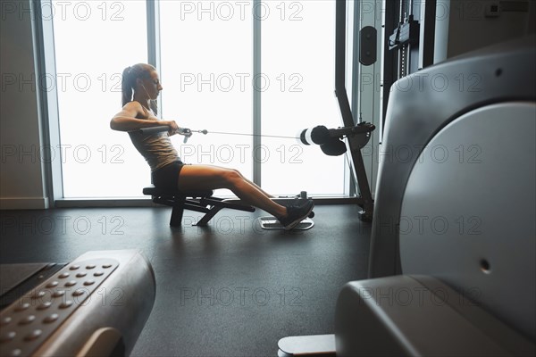 Woman using exercise machine in gym