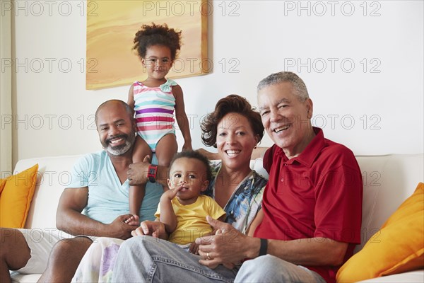 Multi-generation family smiling on sofa