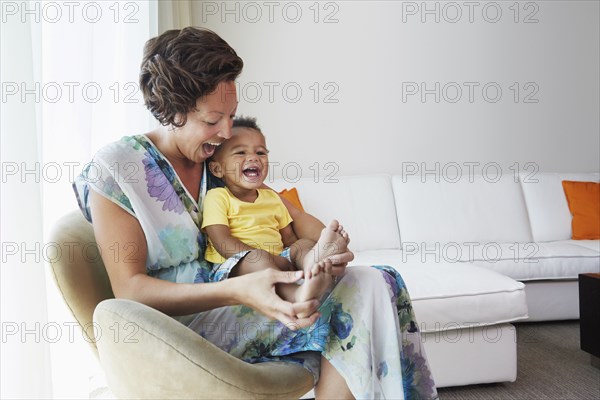 Black mother and son sitting in living room