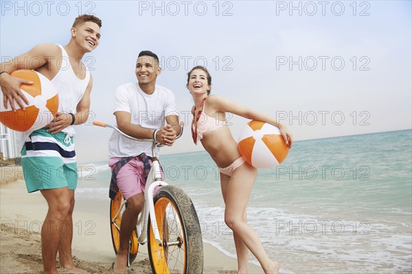 Smiling friends talking on beach