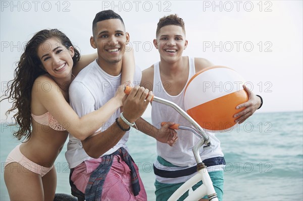 Smiling friends hugging on beach