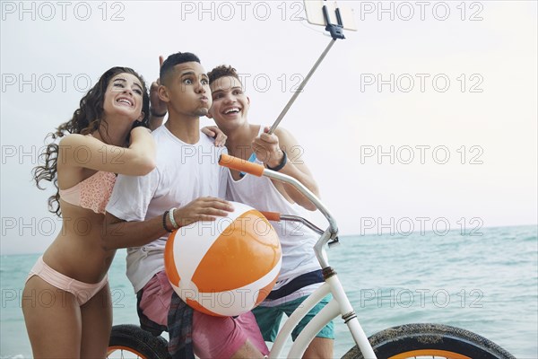 Smiling friends taking selfie on beach