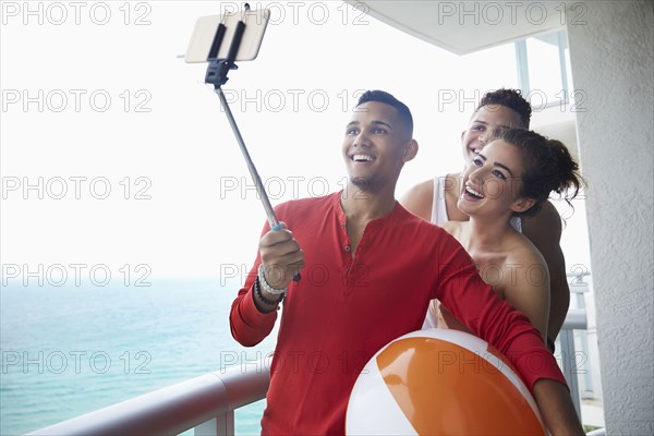 Smiling friends taking selfie on balcony