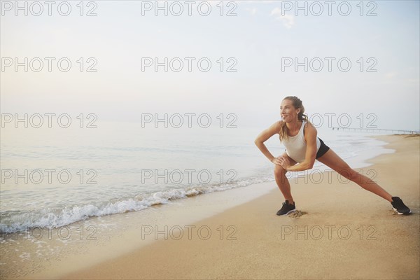 Athlete stretching on beach