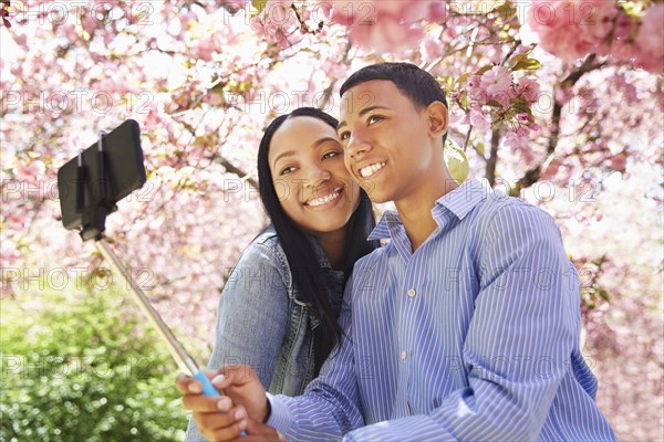 Friends taking self portrait under flowering tree