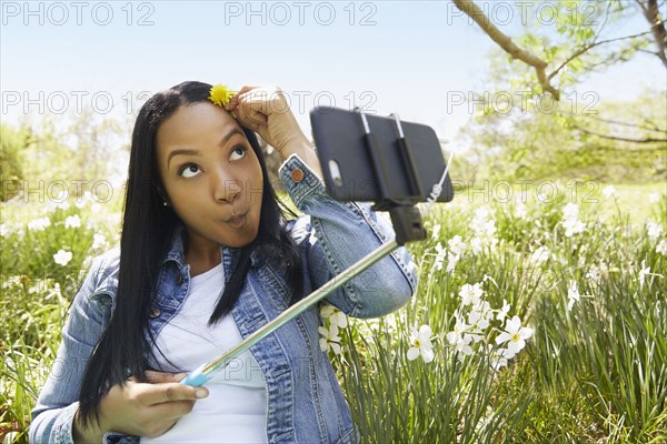 Black woman taking self portrait in park