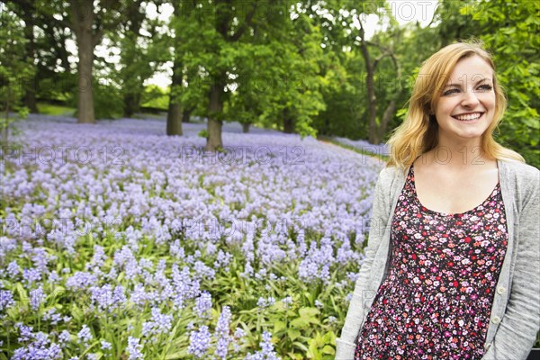 Caucasian woman smiling in field of flowers