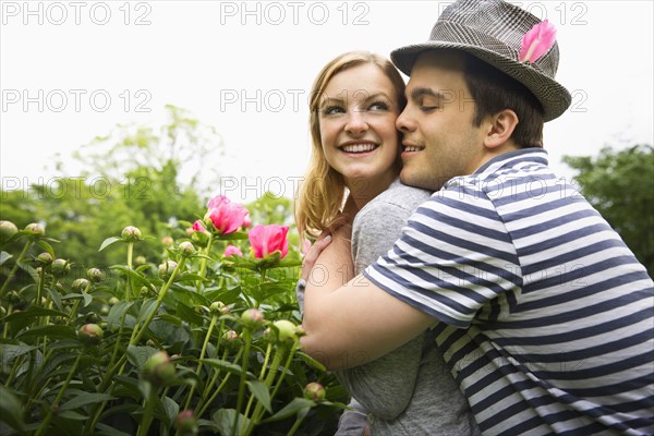 Caucasian man hugging girlfriend in garden