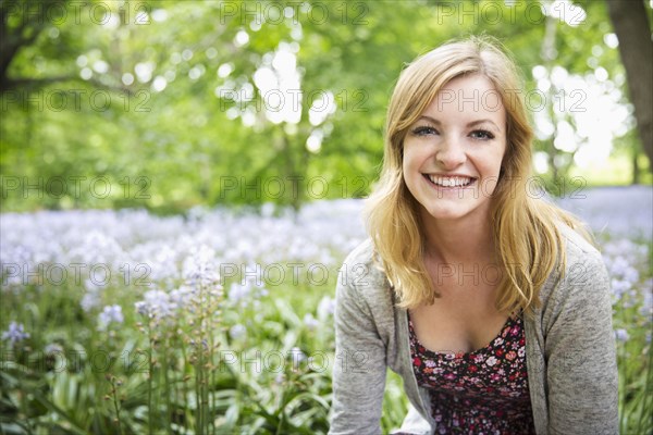 Caucasian woman smiling in field of flowers